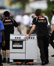Lotus team members move a cooker after a fire in its hospitality unit
