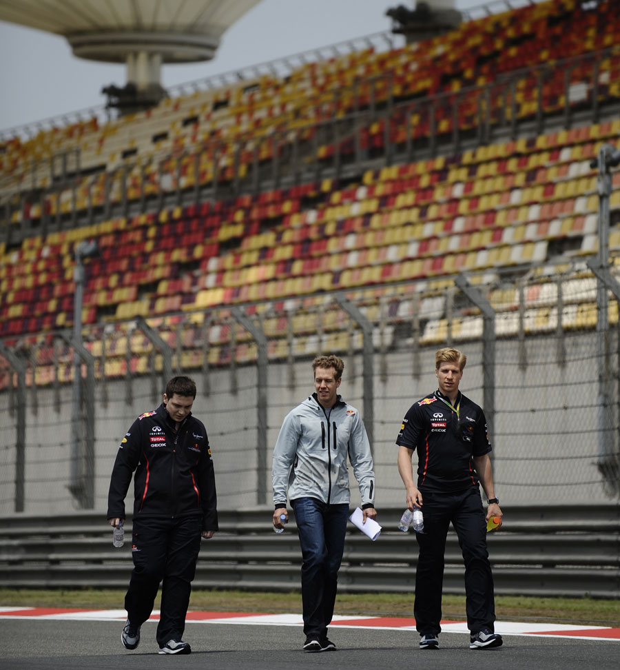 Sebastian Vettel walks the track with his support team on Thursday morning