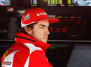 Fernando Alonso on the Ferrari pit wall during a damp first practice session