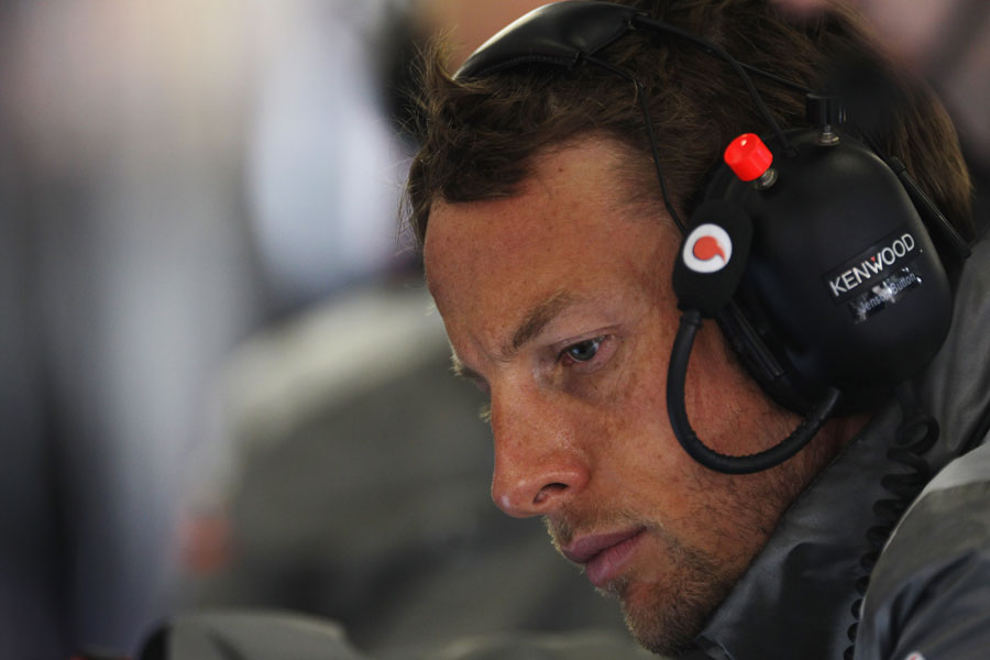 Jenson Button looks concerned in the McLaren garage