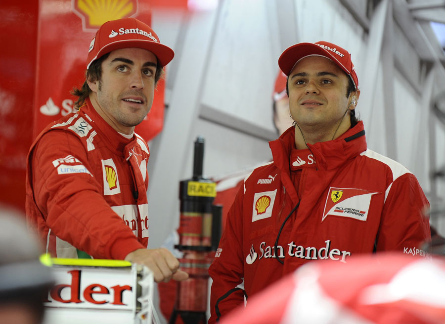 Fernando Alonso and Felipe Massa chat at the back of the Ferrari garage