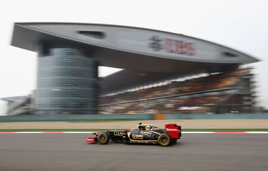 Romain Grosjean speeds past the pit and main grandstand complex