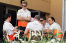Nico Hulkenberg and Paul di Resta chat with team members in the paddock