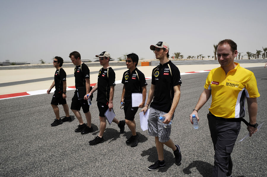 Romain Grosjean walks the track with his Lotus team