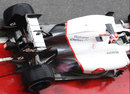 A flame pops from the exhaust of Kamui Kobayashi's Sauber
