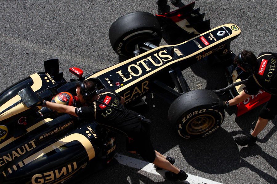 Lotus mechanics wheel Romain Grosjean back into the pits
