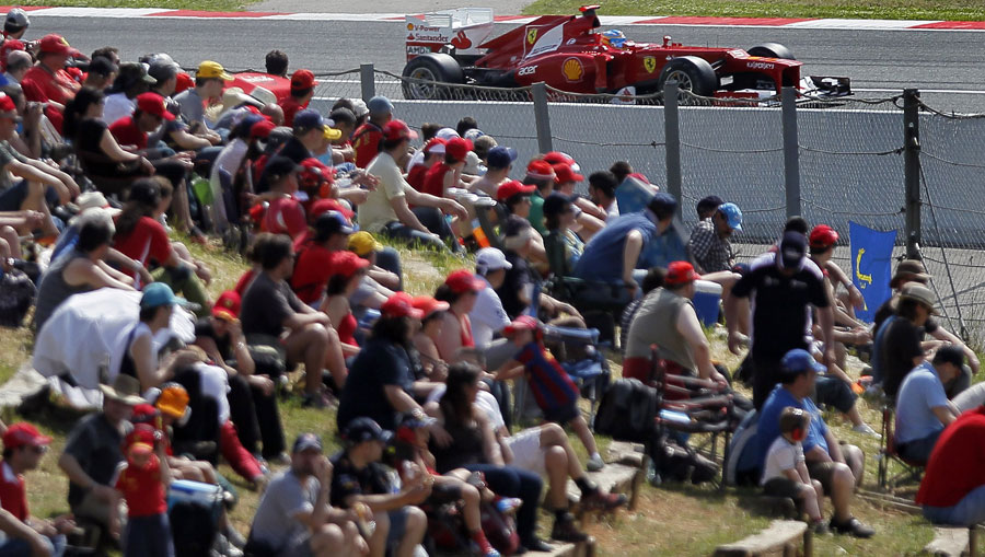 Fernando Alonso passes fans on the grass banking on Saturday morning
