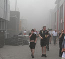 The pit lane is evacuated after a fire in the Williams garage