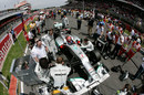 Michael Schumacher prepares to race as his pit crew make last-minute adjustments