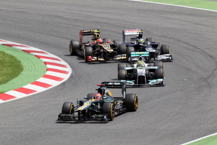 Heikki Kovalainen leads Nico Rosberg through turn one as Romain Grosjean and Bruno Senna battle behind
