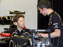 Romain Grosjean talks to his mechanic in the Lotus garage