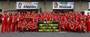 The Ferrari team pose with a banner reading 