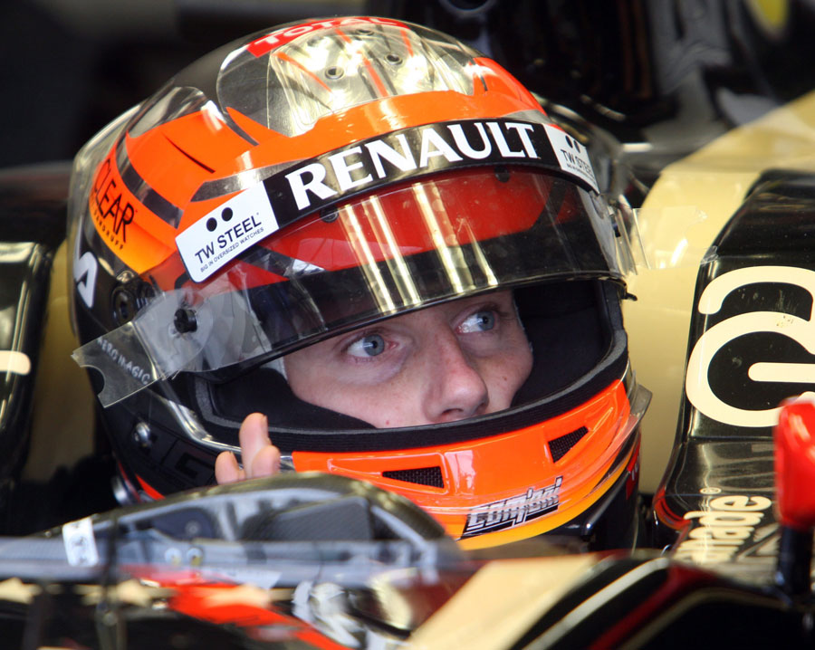 Romain Grosjean speaks to his mechanics in the Lotus garage