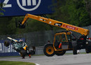 Heikki Kovalainen's Caterham gets lifted away by marshals