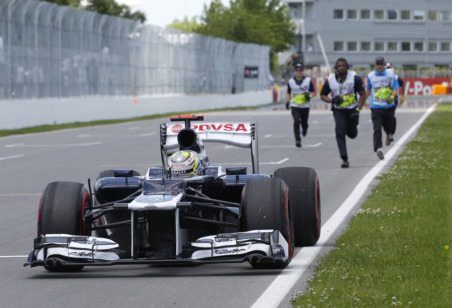Marshals run to move Pastor Maldonado's Williams after he hit the 'Wall of Champions'