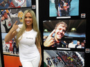 A glamour model poses in front of photos at the Formula One Expo in Austin