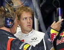 Sebastian Vettel talks to an engineer in the Red Bull garage