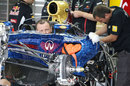 Mechanics work on the Red Bull RB8 carrying a new livery for the Wings for Life charity
