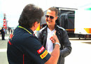 Michael Schumacher speaks to a Toro Rosso team member in the paddock