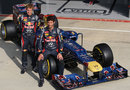 Sebastian Vettel and Mark Webber pose with the Red Bull in its one-off Faces for Charity livery