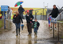 Spectators pick their way through the mud and water