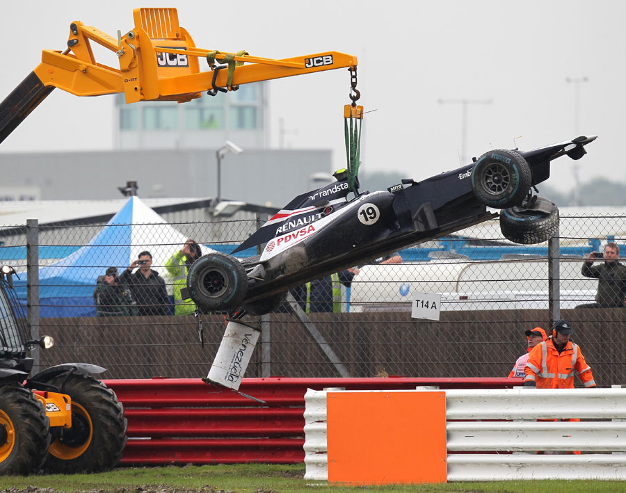 Bruno Senna's Williams is craned away after aquaplaning off the circuit in FP2