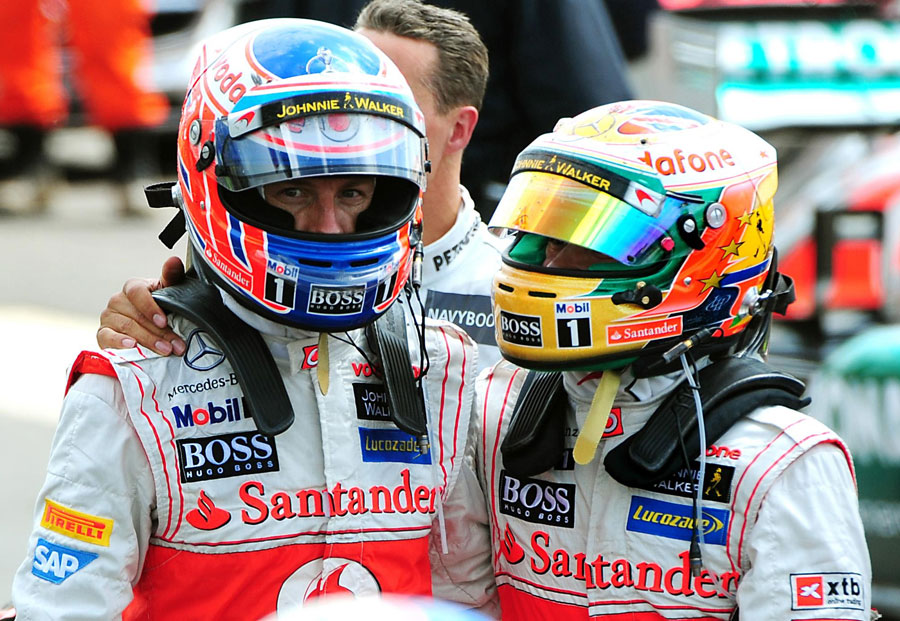 Jenson Button and Lewis Hamilton return to parc ferme after the race
