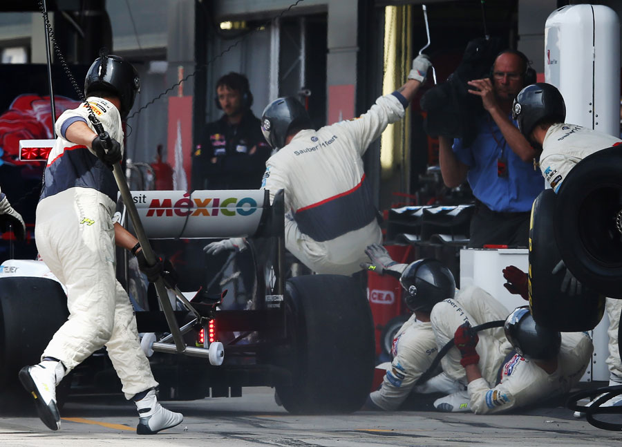 Kamui Kobayashi hits his pit crew at his second pit stop
