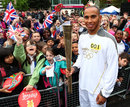 Lewis Hamilton holds the Olympic Flame before his Torch Relay leg through Luton