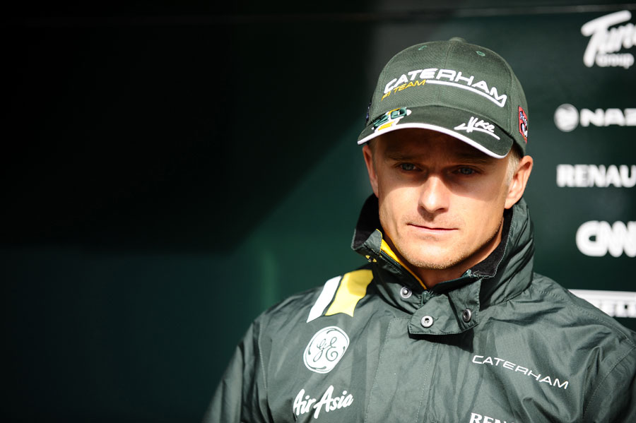 Heikki Kovalainen prepares to face the press during a break in the weather