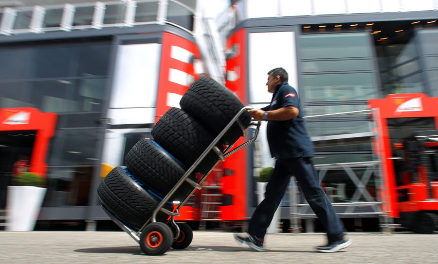 A Toro Rosso team member collects a set of wet weather tyres