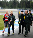 Heikki Kovalainen walks the track with members of the Caterham team