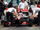 Jenson Button returns to the pits to be greeted by a number of McLaren engineers