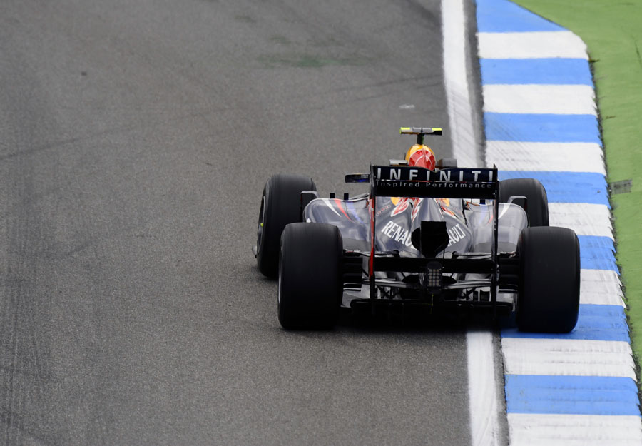Mark Webber uses the kerb on corner exit