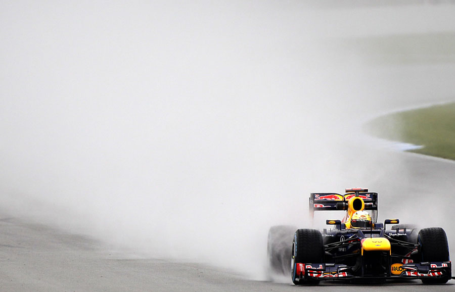 Sebastian Vettel kicks up spray during a wet FP2