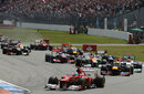 Fernando Alonso leads the field into the first corner as Felipe Massa makes contact in the background