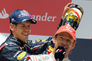 Sebastian Vettel pours champagne down Jenson Button's neck on the podium