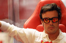 Fernando Alonso looks focused at the back of the Ferrari garage