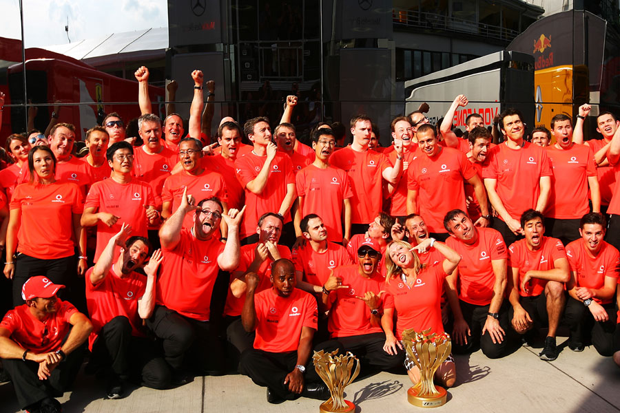 Lewis Hamilton requests the McLaren team to pull faces for the celebration photo