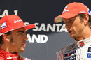 Jenson Button and Fernando Alonso talk on the podium