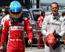 Fernando Alonso and Michael Schumacher walk down the pit lane
