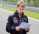 Sebastian Vettel studies some notes as he walks the track