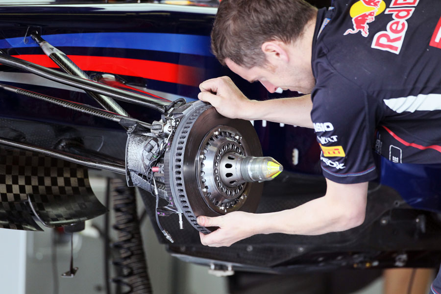 A Red Bull mechanics fits a brake disc