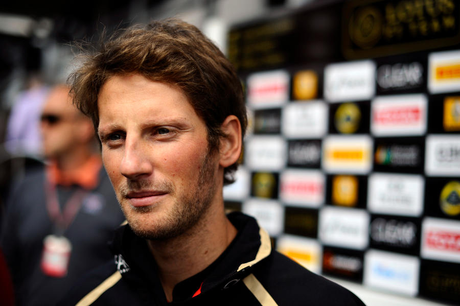 Romain Grosjean speaks to the press outside the Lotus motorhome