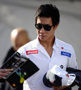 Kamui Kobayashi arrives in the paddock on Sunday morning