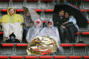 Fans shelter against the weather during Friday practice