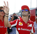 Fernando Alonso salutes fans in the paddock