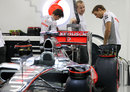 Jenson Button inspects the rear of his McLaren