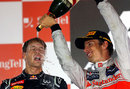 Jenson Button celebrates on the podium with race winner Sebastian Vettel 