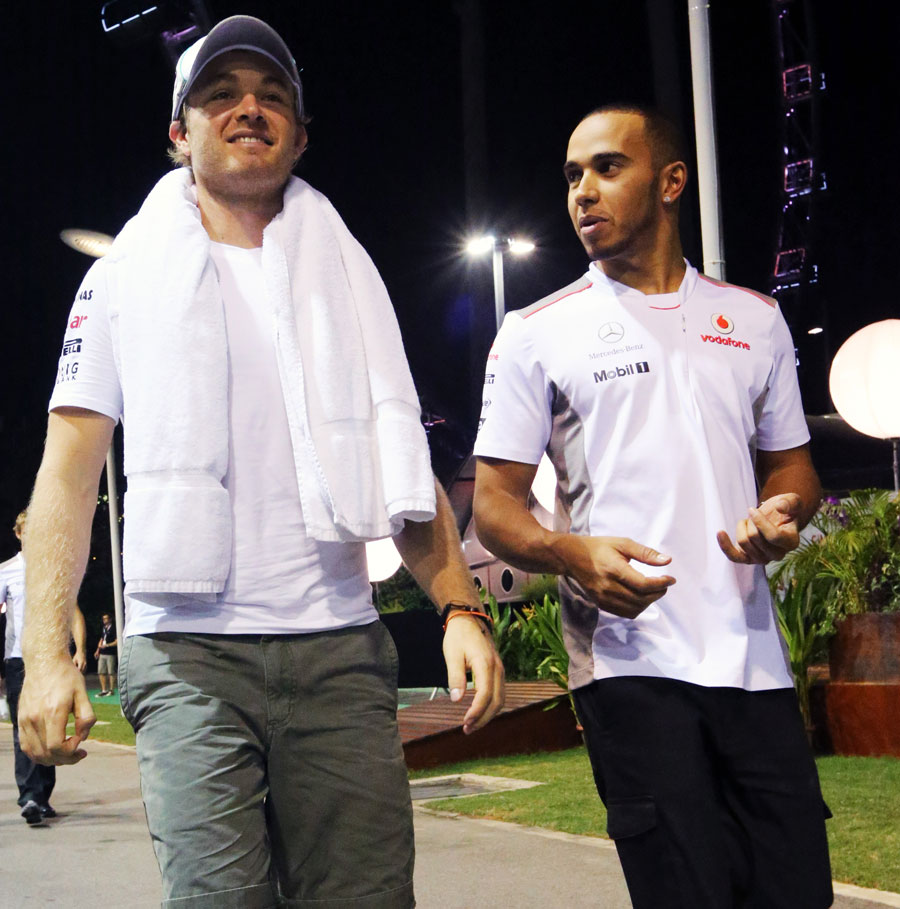 Lewis Hamilton and Nico Rosberg walk through the paddock
